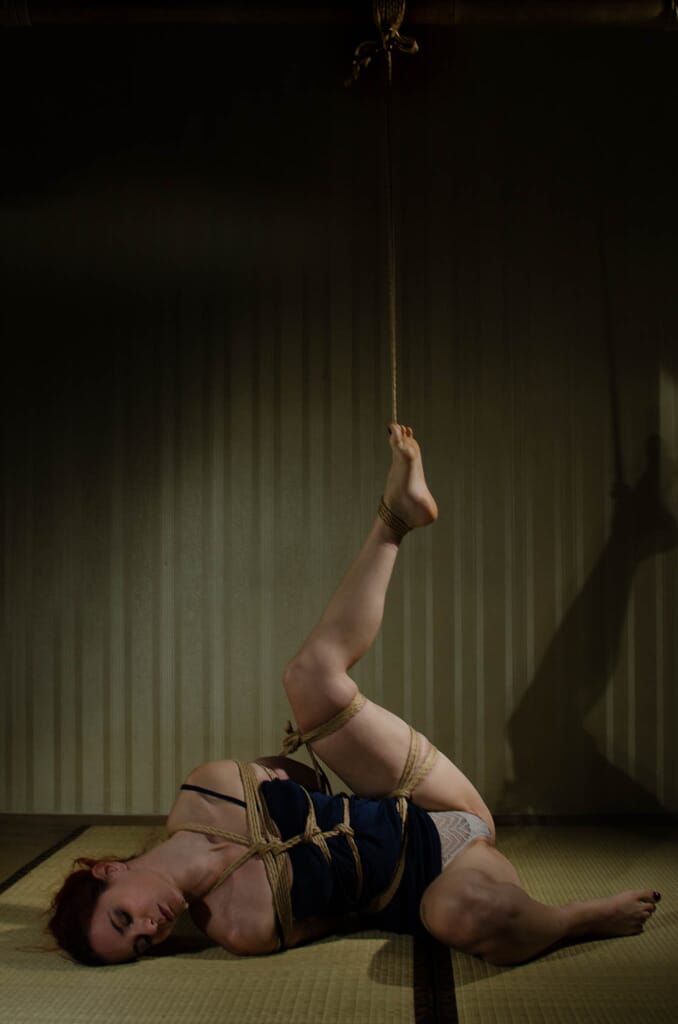 Marta Tenshiko distesa sul tatami con una caviglia sostenuta dalla corda
