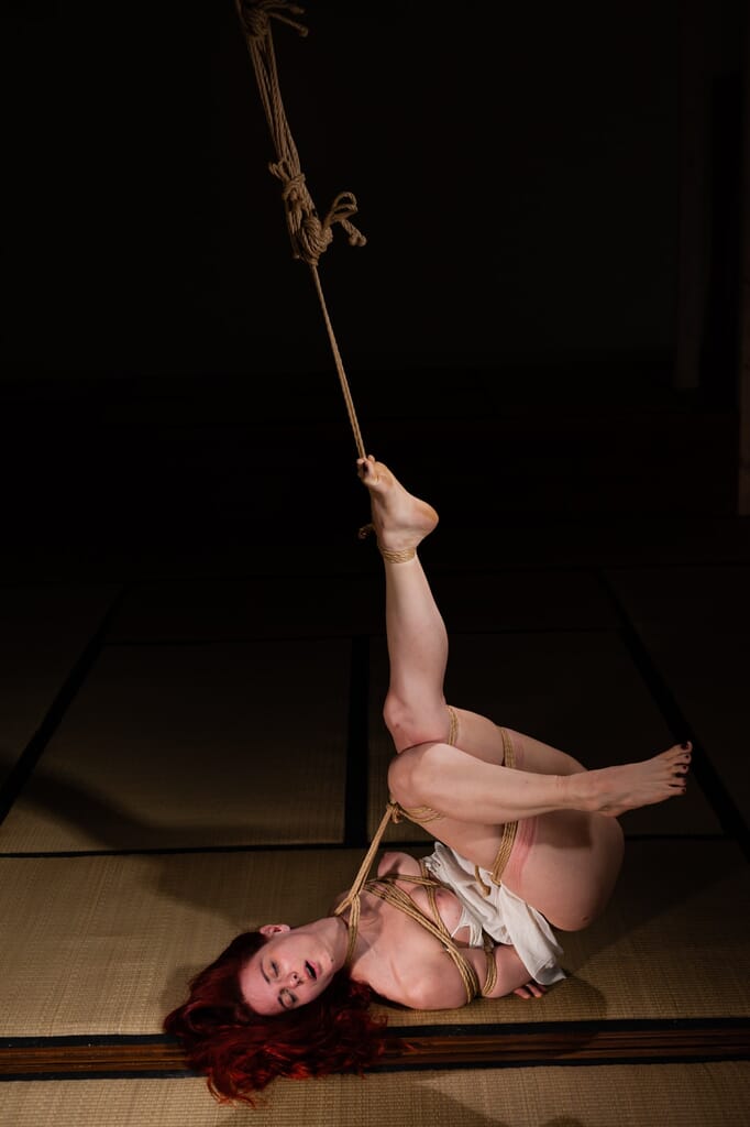 Marta Tenshiko in a diagonal floor pose, with one leg raised and the other extended