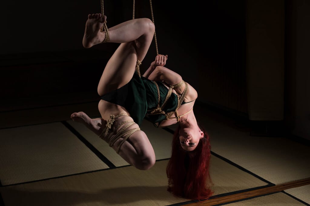 Marta Tenshiko capovolta con il viso vicino al tatami e le ginocchia aperte in tensione, nella progressione di semenawa
