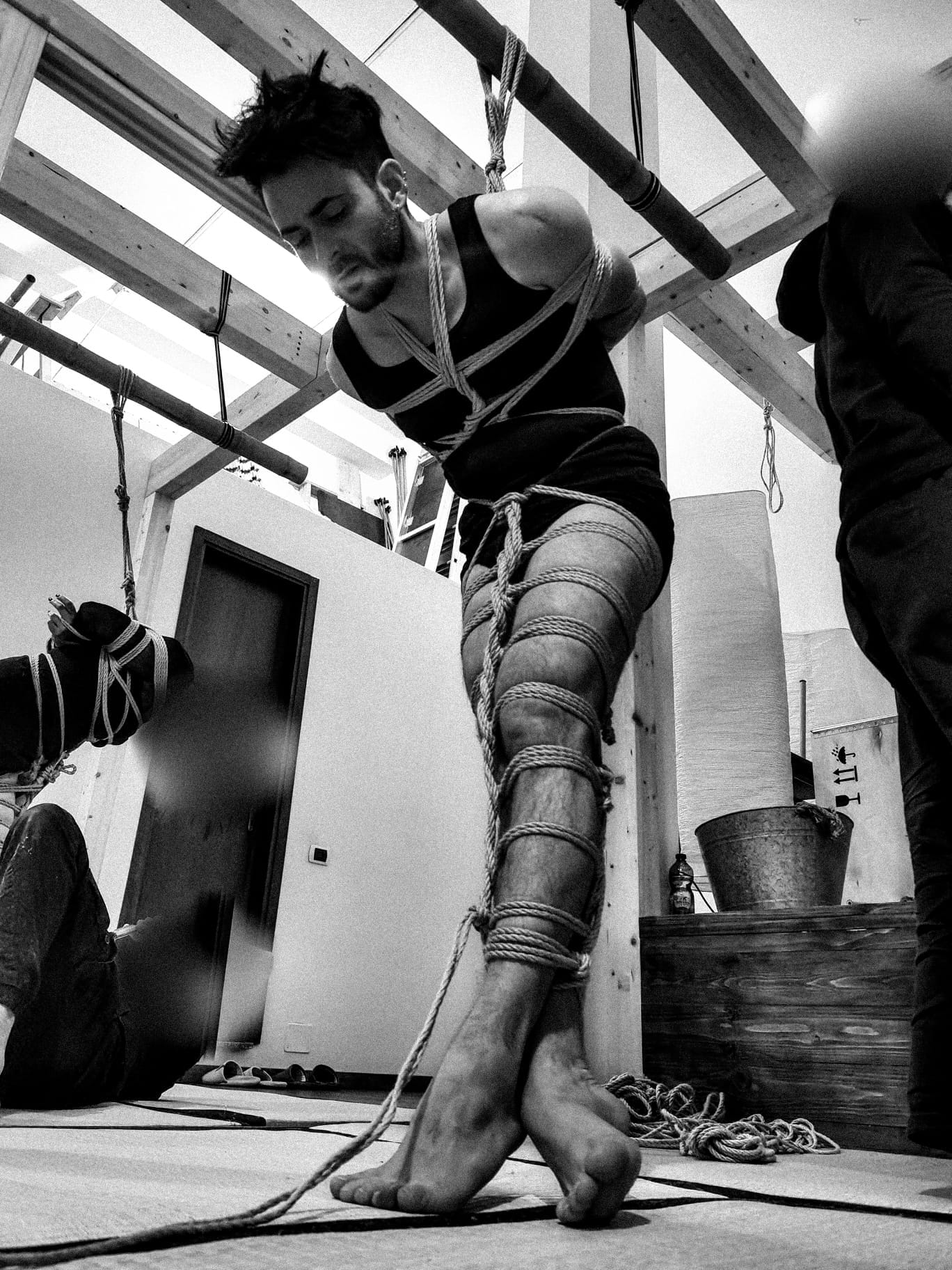 Uomo legato con corde Shibari durante una pratica di Kinbaku